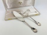 two forks and spoons in a case on the table