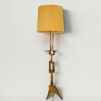un lampadaire en laiton surmonté d'un abat-jour jaune