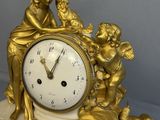 a gold clock sitting on top of a marble block