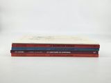 three books stacked on top of each other on a white surface