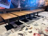 tables and benches in a restaurant with a mural on the wall behind them