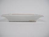 a small white bowl with a red stripe on it