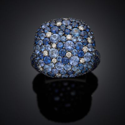 a close up of a ring with blue sapphires and diamonds