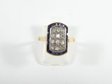 gros plan d'une bague en diamant et saphir sur une surface blanche