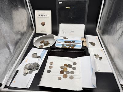 une valise remplie de pièces de monnaie et d'autres objets posée sur une table