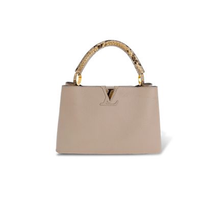 un sac à main beige avec des serpents sur la poignée
