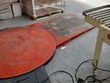 un tapis roulant au milieu d'un entrepôt, avec des palettes
