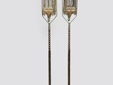 paire de bougeoirs anciens en laiton avec des bougies posées sur leurs socles