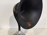 un vieux gramophone noir et argenté posé sur un socle en métal