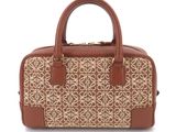 the brown and white handbag is sitting on a white surface