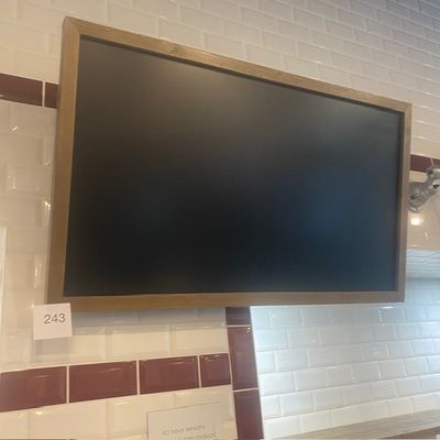 une télévision à écran plat fixée au mur au-dessus d'un lavabo