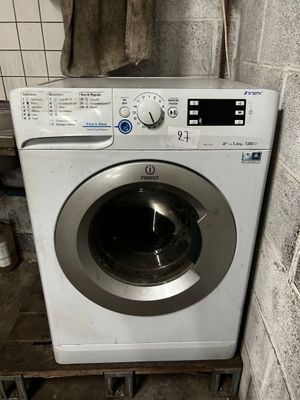 une machine à laver dans un coin d'une pièce sale