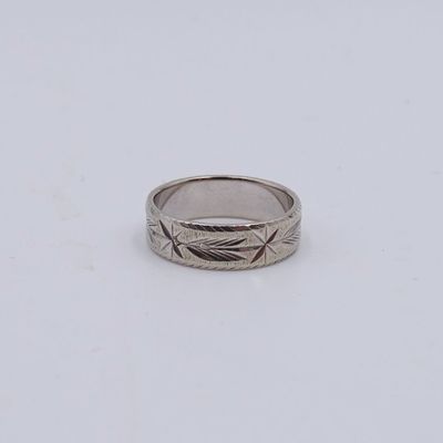 gros plan d'une bague en argent sur une surface blanche
