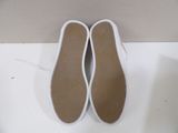 pair of women ' s white tennis shoes on a white surface