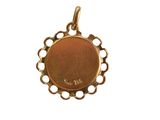 a close up of a gold plated pendant with an oval design
