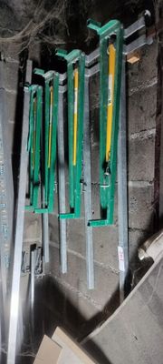 many green and yellow tools hanging on the wall