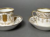 two cups and saucers are sitting on a table