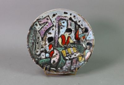 a plate with a painting on it sitting on a table