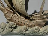 a statue of a ship on a body of water