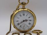 une montre à gousset en or avec une chaîne autour d'elle