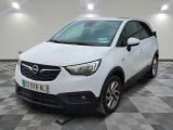L'Opel blanche est garée dans une grande pièce au sol carrelé en damier.
