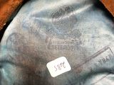 brown leather hat with a label on it sitting on top of a table