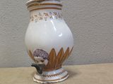 a white and gold vase sitting on a table
