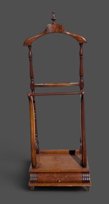 un vieux porte-manteau en bois surmonté d'un cintre