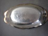 a silver plate on a table with a black background