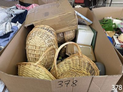 a cardboard box filled with wicker baskets and other items