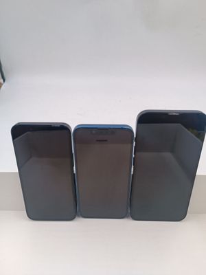 trois iPhones noirs posés les uns à côté des autres sur une table