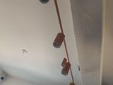 une photo d'un salon avec un ventilateur de plafond et un tableau accroché au mur