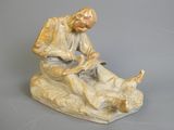 une figurine représentant un homme assis sur un rocher
