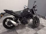 a black motorcycle parked in a room with a checkered floor