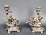 pair of antique brass candlesticks with figurines of a woman and a turtle