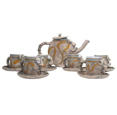 three cups and a teapot sitting on a saucer