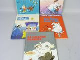 quatre livres pour enfants sont alignés sur une surface blanche
