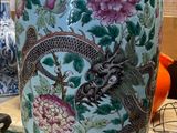 un vase orné d'un dragon posé sur une table