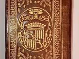 an old book with a gold cover and a crown on it