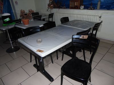 a table and chairs in a room with a blue tarp on the table