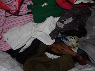 a pile of clothes on a bed in a room