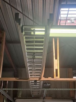 a ladder that is hanging from the ceiling in a garage
