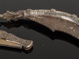 two pieces of silver on a black surface