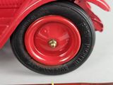 a red toy car that is sitting on a table