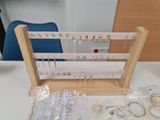 a display of jewelry on a table with a blue chair in the background