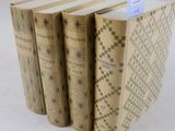 trois livres sont empilés sur une surface blanche
