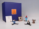 toy figurines of a man sitting on the ground in front of a blue box