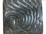 une image représentant une boucle de ceinture en métal ornée d'un motif