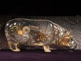 a glass sculpture of a pig with gears inside of it