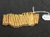 a close up of a gold bracelet on a black surface